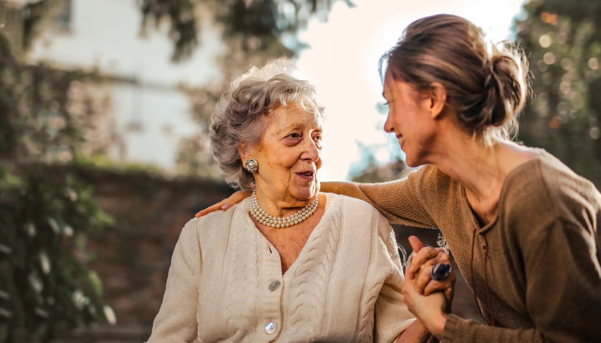 A caregiver and resident sharing a warm moment outdoors at Amber Grove
